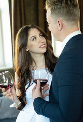 Young newlywed couple drinking wine and smiling at their happiness, romance and tenderness