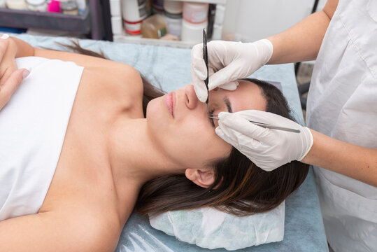 jeune femme dans un centre esth&eacute;tique effectuant des soins de beaut&eacute; dans le profilage des sourcils et le service des cils.
