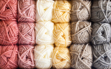 Clews of threads for knitting of different colors are stacked on the shelves, close-up.
