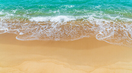 Fototapeta na wymiar Sand beach seaside with white foamy and wave from blue sea, landscape seashore in summer season