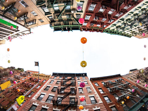 Looking up at historic buildings on Mott Street in the Chinatown neighborhood of New York City with fisheye lens effect