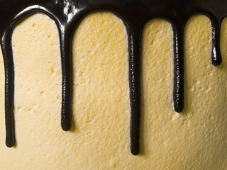 chocolate streams on a yellow cake. cream texture. macro