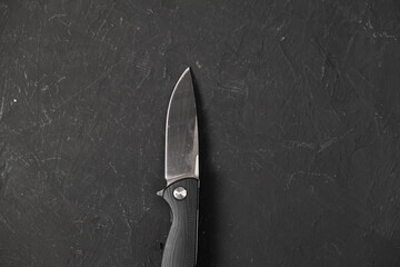 sharp pocketknife on a black background - obrazy, fototapety, plakaty