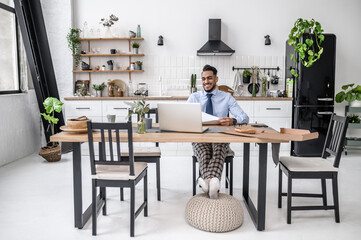 A dark-haired businessman having online meeting at his home office