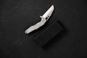 sharp pocketknife on a black background - obrazy, fototapety, plakaty