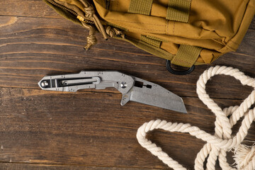 stainless steel folding knife with wooden handle and other everyday carry (EDC) items for men. closeup at folding knife.
