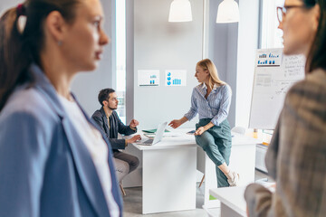 Business professionals standing together and having casual discussing in office.