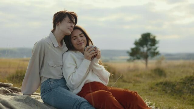 Two lesbians embracing and talking on fresh air