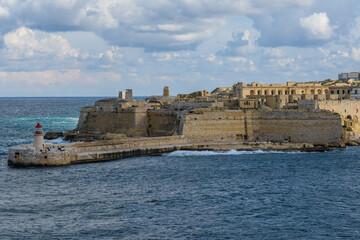 Clouds over the 17th century Fort Ricasoli and the breakwater with the lighthouse at the entrance to the Grand Harbour in Malta.