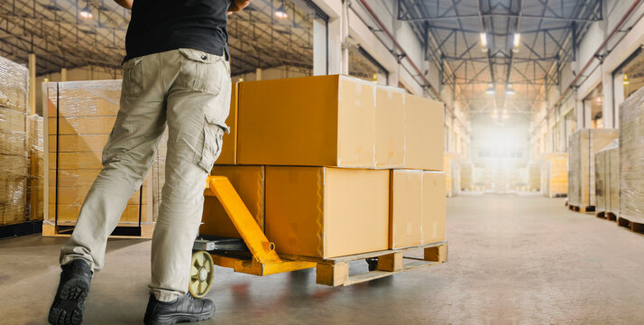 Workers Unloading Packaging Boxes on Pallet in Distribution Warehouse. Cardboard Boxes. Shipping Supplies Warehouse. Shipment Boxes. Storehouse.  Cargo Warehouse Logistics.	