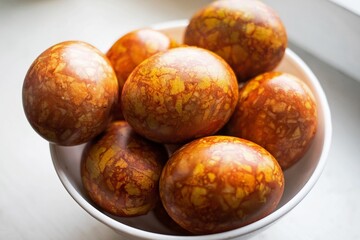 colored colorful chicken eggs in a large white plate as a symbol of the national holiday of believers