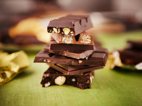 Stack of Assorted Chocolate Bars on Green; Wrappers