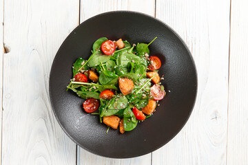 Salad with red fish and tomatoes in a plate. On a light background.