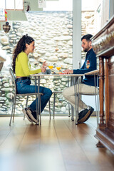 Young tourist couple talking and having breakfast in a hotel