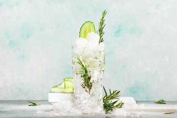Gin tonic with cucumber, alcoholic cocktail drink with dry gin, rosemary, tonic, fresh cucumber and ice cubes. Gray background, bar tools, copy space - obrazy, fototapety, plakaty