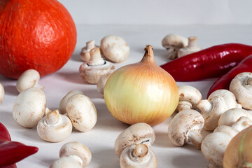 Ingredients for a vegetarian dish. Fresh vegetables and mushrooms. Onion, pumpkin, red pepper, mushrooms