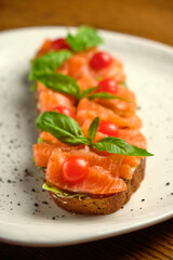Bruschetta with pickled trout and salmon basil and tomatoes