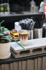 Closeup of Iced Caramel Macchiato at the coffee shop, Caramel Macchiato is a classic macchiato beverage. It consists of vanilla syrup, espresso, steamed milk, foam, and caramel drizzle          