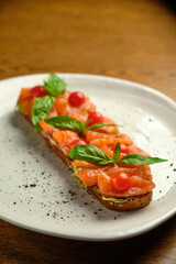 Bruschetta with pickled trout and salmon basil and tomatoes