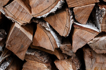A stack of firewood. Preparation of dry trees for the winter for heating. Chopped wood for a fireplace, stove
