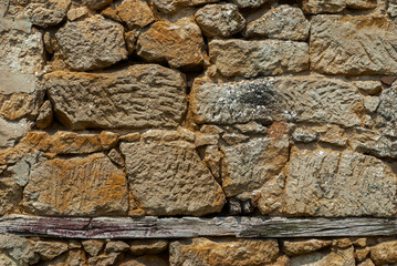 Old stone wall. The wall is made of sandstone of irregular shape.