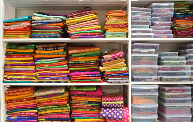 Colorful sarees or saris are arrange on racks and display in a retail shop, for use as indian...