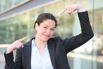 Proud businesswoman pointing herself in the street