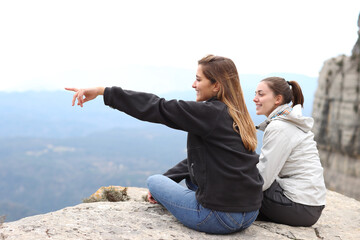 Two happy trekkers sitting contemplating views outdoors