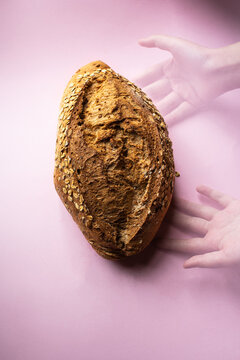 Sourdough oatmeal bread with hands. Multple exposure composition. Top view.