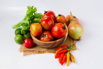 Fruits and vegetables in wooden bowl on white background