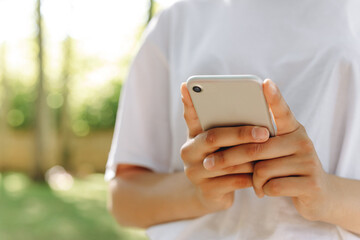 A beautiful female is walking and doing something with a phone.