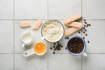 Tiramisu dessert. Ingredients for making dessert tiramisu. Cooking Italian food dessert Tiramisu with all necessary ingredients cocoa, coffee, mascarpone cheese on grey stone background. Copy space