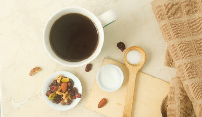 cup of coffee, white plates with nuts, sugar, and a kitchen towel in a kitchen top  - Powered by Adobe