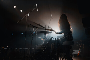 girl drummer on stage behind the kit