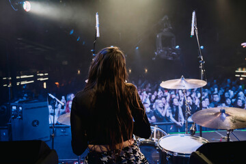 girl drummer on stage behind the kit