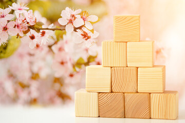 The pyramid is built of wooden cubes against the backdrop of a flowering garden. Banner mockup for...