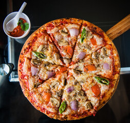 Vegetarian pizza in a restaraunt setting with spicy ezay