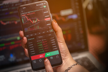 Women's hands are looking at data and making arbitrage trading on cryptocurrencies market on smart...