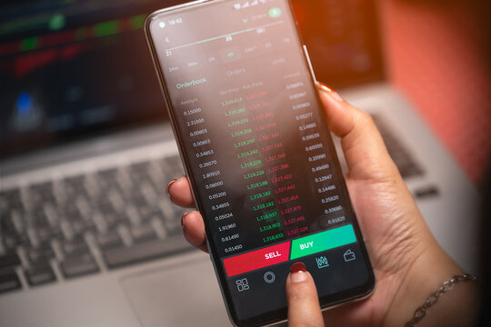 Women's hands are looking at data and making arbitrage trading on cryptocurrencies market on smart phones.
