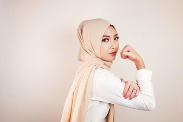 Gorgeous strong young Muslim woman isolated over white background wall showing biceps.