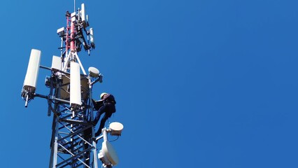 Engineer technician climbing 5G tower antenna for routine maintenance work using smart laptop and professional safety equipment - Powered by Adobe