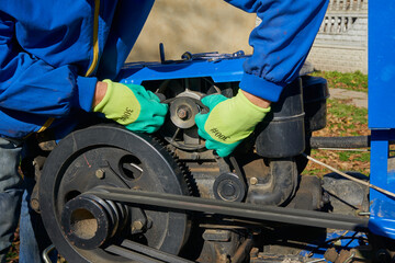 tractor generator repair,a man replaces a worn cracked generator belt on a two-wheeled tractor