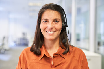 Glückliche Geschäftsfrau mit Headset als Kundenberater
