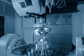 The five axis CNC milling machine cutting the metal gear part.