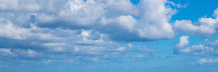 Fototapeta premium Clouds are in blue sky on a summer day, panoramic background photo