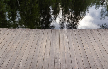 Old wooden pier and still lake water