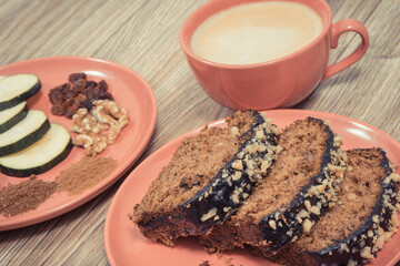 Fresh pastry made of zucchini and cup of white coffee. Delicious dessert. Wooden background