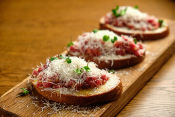 Beef tartar with salad and garlic toast on dark bread