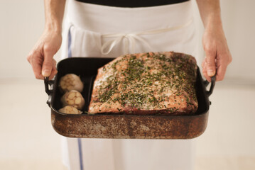 Chef Holding a Pan with Prime Rib Roast with Garlic