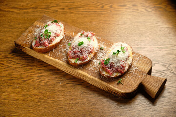 Beef tartar with salad and garlic toast on dark bread